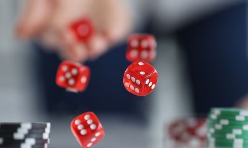 Red dice flying over casino chips closeup. Game addiction concept
